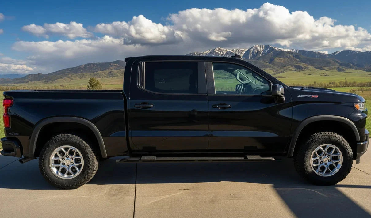 Black Silverado ZR2 with two mounted side steps and mountains behind